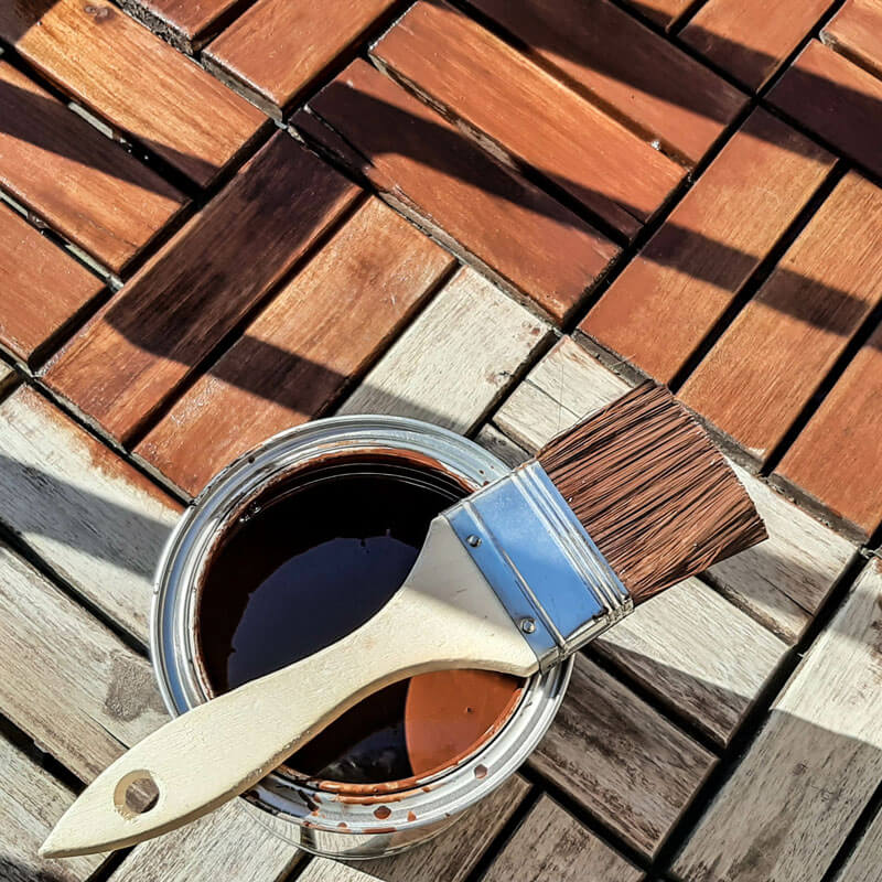 Wood-oil-pot-and-brush-at-wooden-terrace